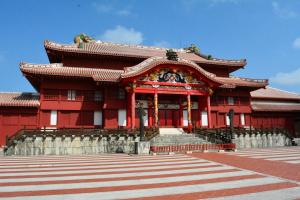 Vue majestueuse du château de Shuri à Okinawa, baignant sous un ciel azur. Les murs en pierre robustes de ce monument historique, ornés de détails architecturaux traditionnels, témoignent de la riche histoire et du patrimoine culturel de l'île. Les toits en tuiles rouges, caractéristiques de l'architecture d'Okinawa, brillent sous le soleil, tandis que les jardins luxuriants qui entourent le château ajoutent une touche de verdure et de sérénité à cette scène emblématique.